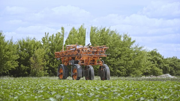 An autonomous tractor spraying crops in a field, using precise application technology to minimize waste and environmental impact. The tractor is equipped with advanced sensors that monitor crop health and adjust the spraying process accordingly.