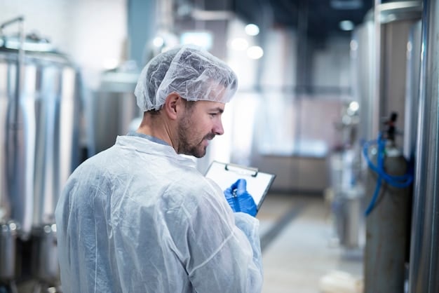 An FDA inspector in protective gear examining food production equipment in a processing plant, with a focus on hygiene and safety protocols. The image should convey the thoroughness of the inspection process.