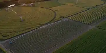 Aerial view of US farm with precision irrigation systems, demonstrating water efficiency.